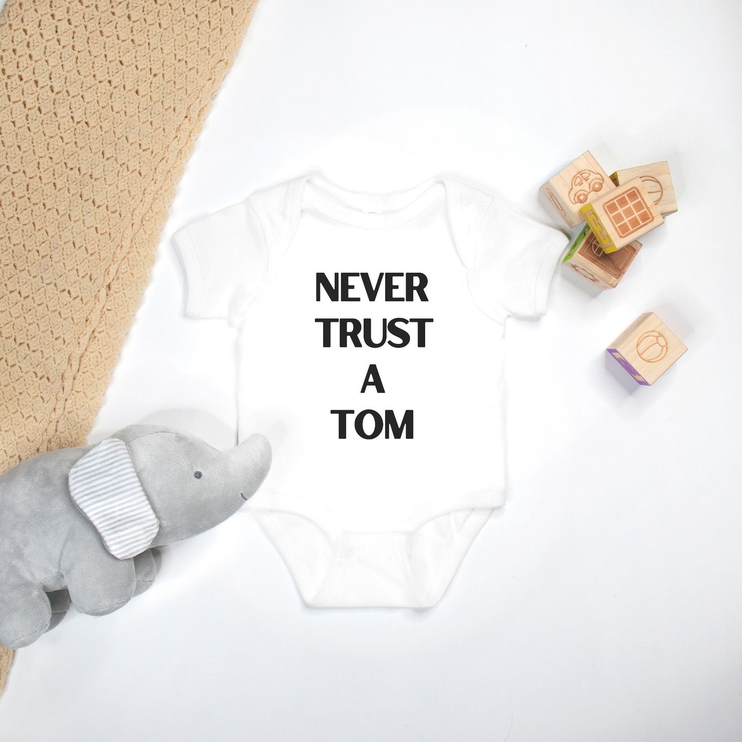 Never Trust A Tom Baby Onesie